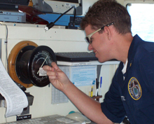 Barometer check: NOAA Corps officer checks the barometer during a fisheries cruise.