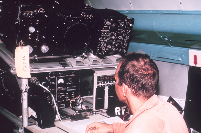 A radar technician sits at a radar scope. 