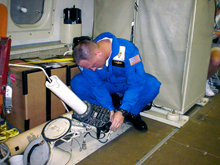 A crew member prepares to  deploy a dropwindsonde
