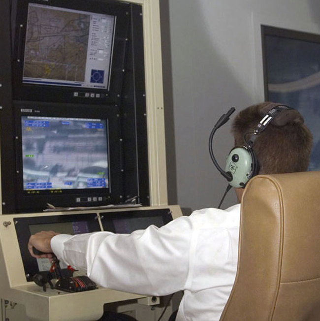 Pilot navigates flying the Altair unmanned aircraft system at a console.