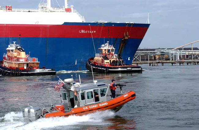 A U.S. Coast Guard vessel escorts an LNG bulk carrier into Boston Harbor.